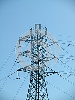 High Voltage Power Lines intersect at a large metal Utility pole