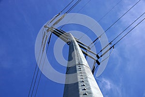 High Voltage Power Lines intersect at a large metal Utility pole