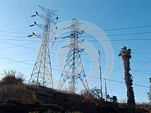 High Voltage Power Lines intersect at two large metal Utility pole