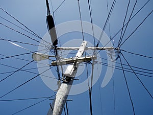 High Voltage Power Lines intersect at a wooden Utility pole