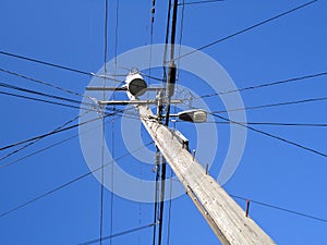 High Voltage Power Lines intersect at a wooden Utility pole with