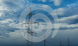 High-voltage  power lines at storm clouds