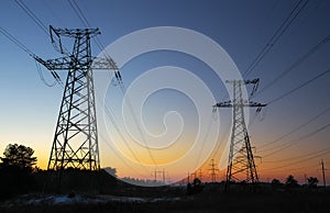 High-voltage power lines during sunrise