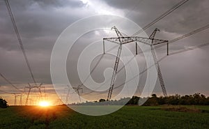 High-voltage power lines at sunset. greeb field.