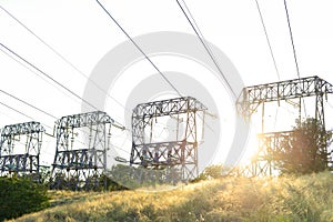 High-voltage power lines at sunset. High voltage electric transmission tower. blackouts.