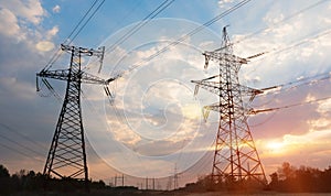 High-voltage power lines at sunset or sunrise. High voltage electric transmission tower