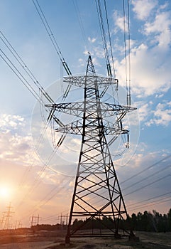 High-voltage power lines at sunset or sunrise. High voltage electric transmission tower