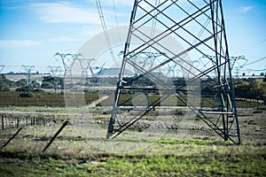 High Voltage Power Lines Towering Over a Rural Landscape on a Clear Day