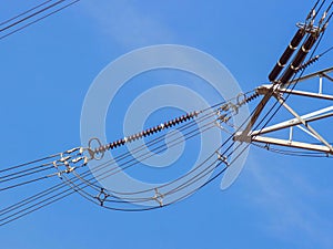 High voltage power pylons against blue sky