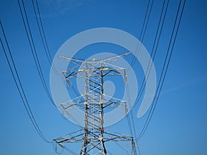 A high voltage power pylons against blue sky