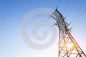 High voltage power tower over blue sky background