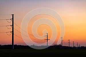 High voltage power tower over sunset clear sky, blackout concept