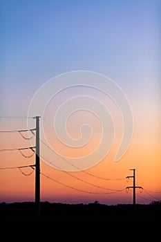 High voltage power tower over sunset clear sky, blackout concept