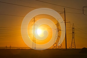 High-voltage power transmission line. Energy pillars. At sunset, dawn. high-tension