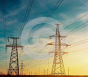 High-voltage power transmission towers in sky background.