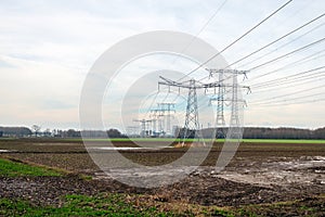 High-voltage pylons and high-voltage lines for transporting electricity from the power plant in the background