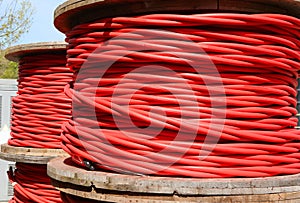 High-voltage red electrical cable reels that can carry up to 30000 volts to connect electrical substations