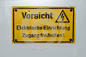 High Voltage Sign Warning in German saying Electric device do not cover on Electric Control Box