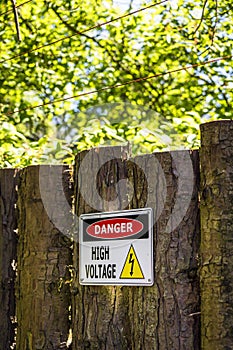 High voltage sign on a wooden fence photo