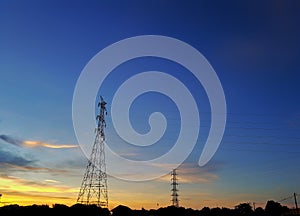 High voltage tower with a background in the evening sky, silhouette concept.