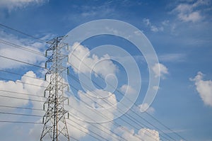 High voltage tower and electric line over cloudy blue sky