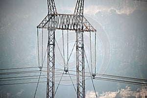 High voltage tower with electric power lines divided by safe guard bushing transfening safely electrical energy through