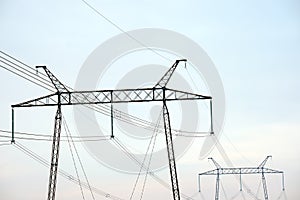 High voltage tower with electric power lines transfening electrical energy through cable wires