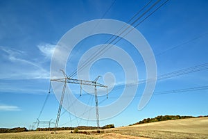 High voltage tower with electric power lines transfening electrical energy through cable wires