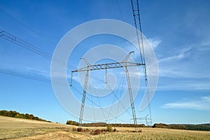 High voltage tower with electric power lines transfening electrical energy through cable wires