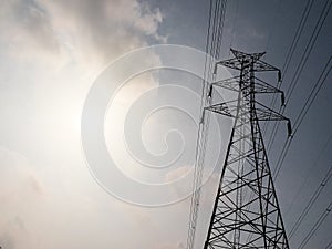 High voltage tower or electricity transmission power lines in the cloudy blue sky