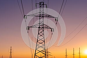 High voltage tower. High voltage. Electricity transmission power lines at sunset (high voltage pylon). Aerial view