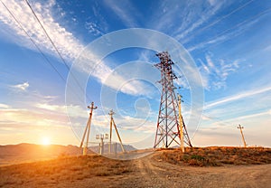 High voltage tower in mountains at sunset. Electricity pylon system