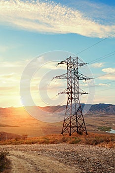 High voltage tower in mountains at sunset. Electricity pylon system