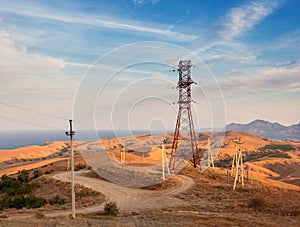 High voltage tower in mountains at sunset. Electricity pylon system