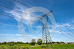 High voltage tower - Power Line in Countryside against a Blue Sky with Clouds