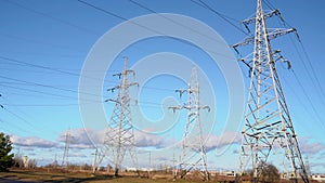 High voltage tower with power lines against a sky with clouds.