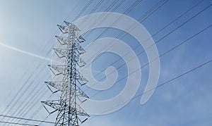 High voltage tower silhouetted against blue sky