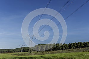 High voltage towers that carry cable lines and cross a forest