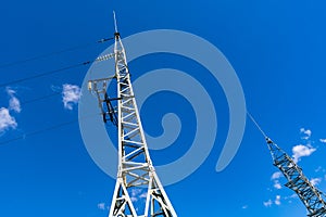 High voltage towers with electricity transmission power lines against sky background