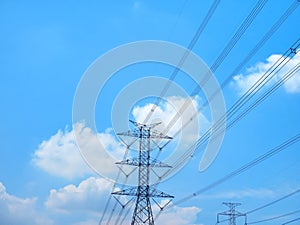 High Voltage Towers and Power Lines Against Blue Cloudy Sky