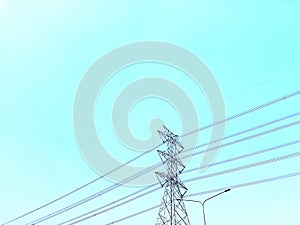High Voltage Towers and Power Lines Against Clear Blue Sky
