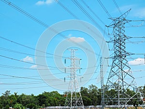 High Voltage Towers and Power Lines Against Vibrant Blue Cloudy Sky