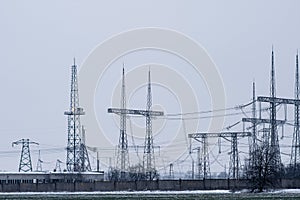 High voltage towers at a powerful electrical substation.