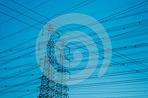 High-voltage towers silhouetted against blue