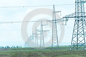 High voltage towers with sky background. Power line support with wires for electricity transmission. High voltage grid