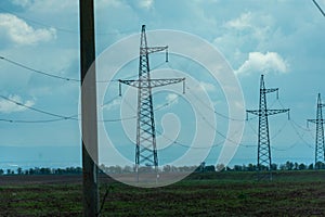 High voltage towers with sky background. Power line support with wires for electricity transmission. High voltage grid