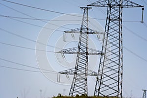 High voltage towers with sky background. Power line support with wires for electricity transmission. High voltage grid