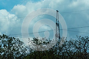 High voltage towers with sky background. Power line support with wires for electricity transmission. High voltage grid