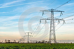 High voltage towers with thick hanging power cables in a rural l