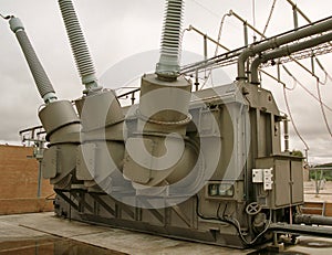 High voltage transformer tank and turrets and grey sky photo